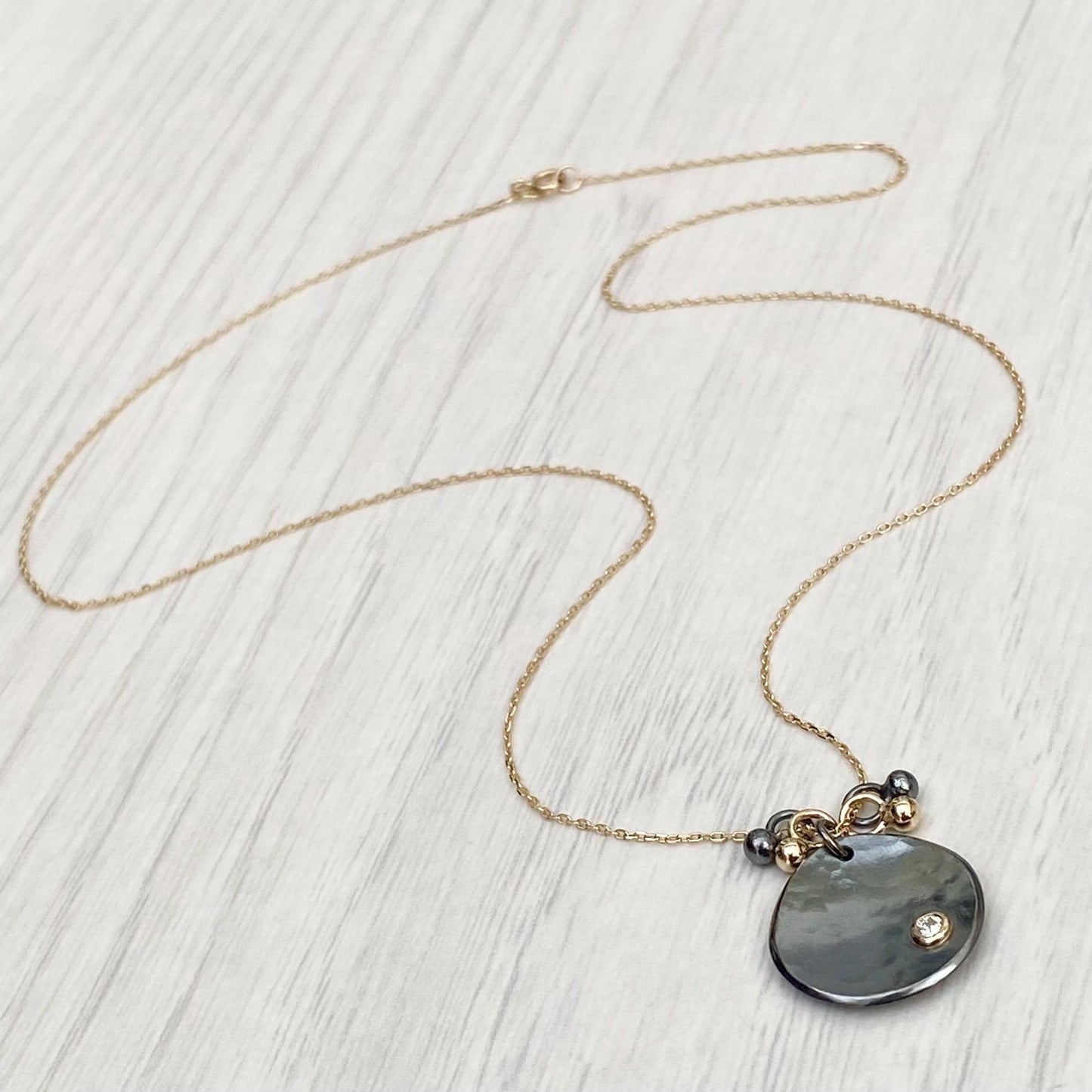 Oxidised solid sterling silver and 9ct yellow gold diamond petal pendant on a fine 9ct yellow gold chain with seed detail