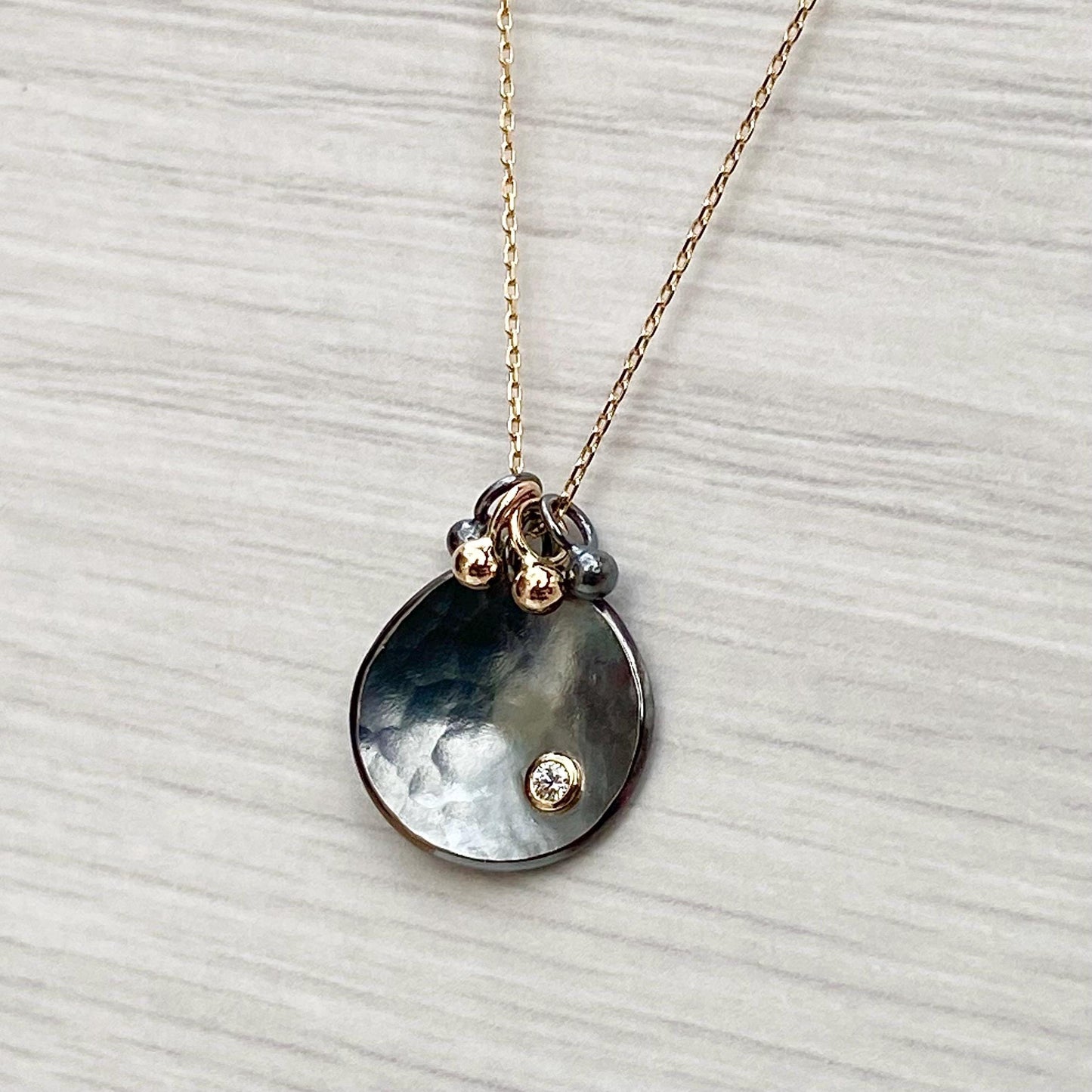 Oxidised solid sterling silver and 9ct yellow gold diamond petal pendant on a fine 9ct yellow gold chain with seed detail