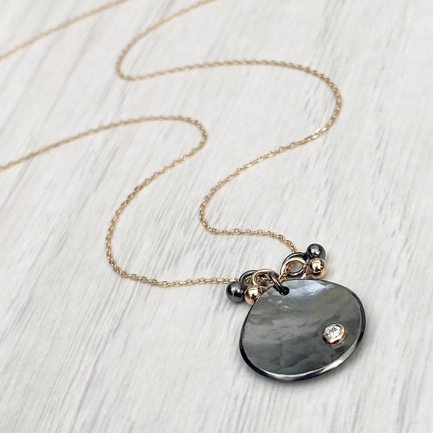Oxidised solid sterling silver and 9ct yellow gold diamond petal pendant on a fine 9ct yellow gold chain with seed detail