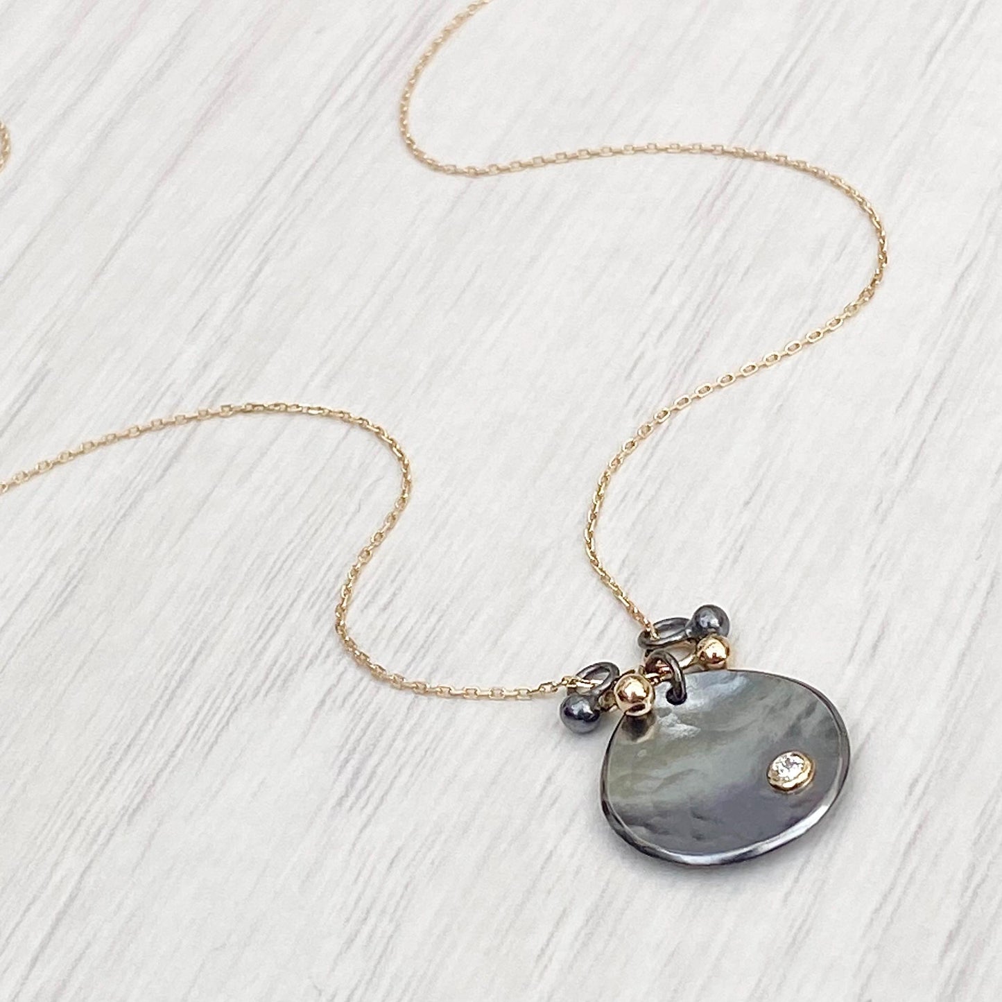 Oxidised solid sterling silver and 9ct yellow gold diamond petal pendant on a fine 9ct yellow gold chain with seed detail