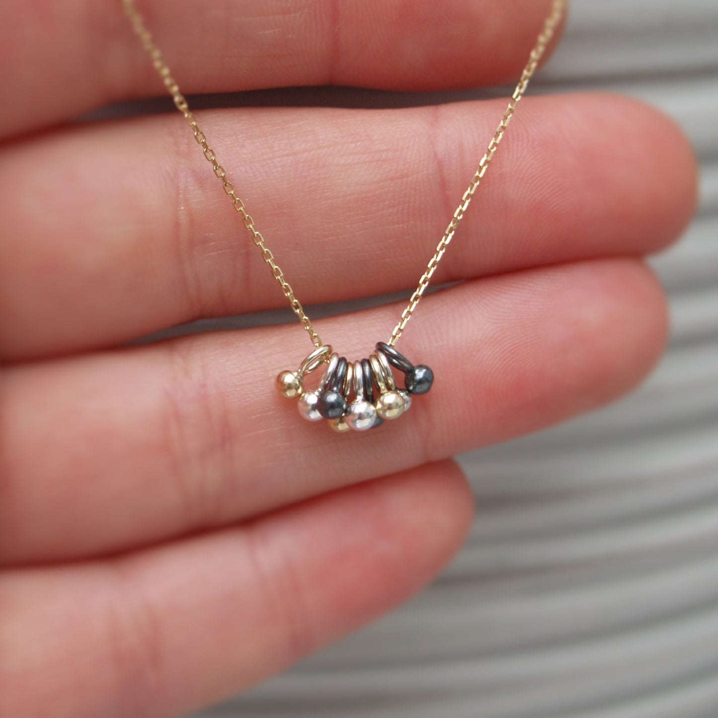 9ct solid yellow gold, silver and oxidised silver tiny seed ball pendants on a 9ct yellow gold chain