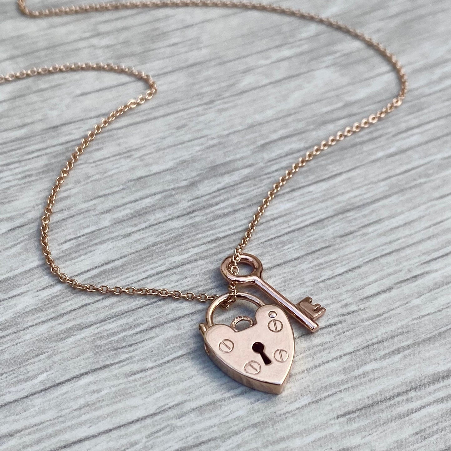 9ct solid rose gold heart padlock and small key charm pendants on a 1.2mm wide trace chain