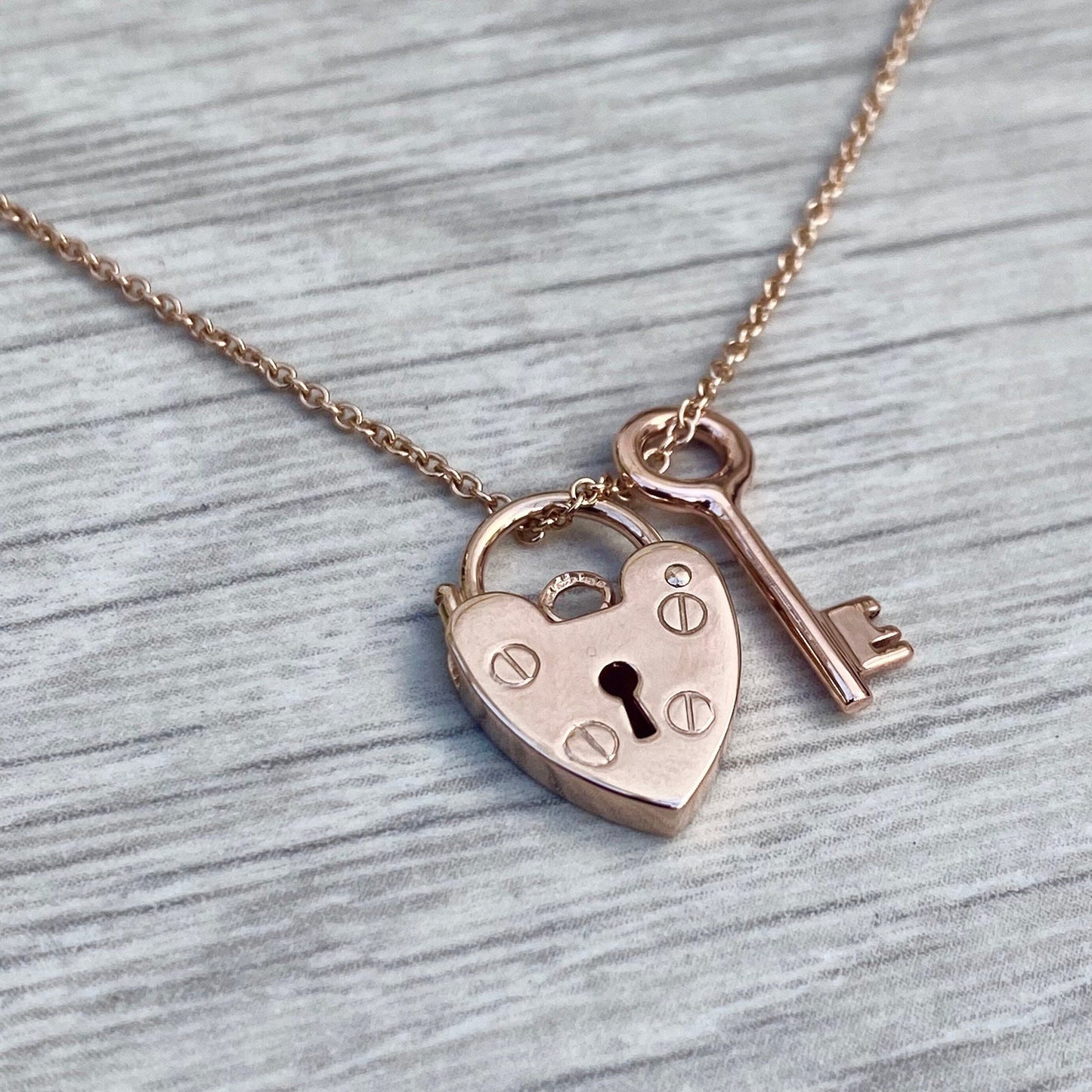 9ct solid rose gold heart padlock and small key charm pendants on a 1.2mm wide trace chain