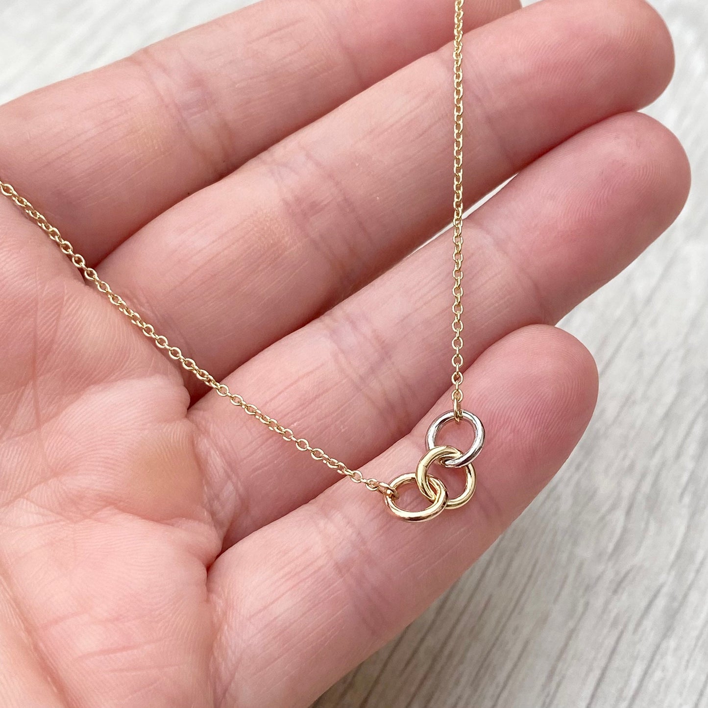 9ct solid yellow, white and rose gold three linked rings necklace with a 9ct yellow gold trace chain