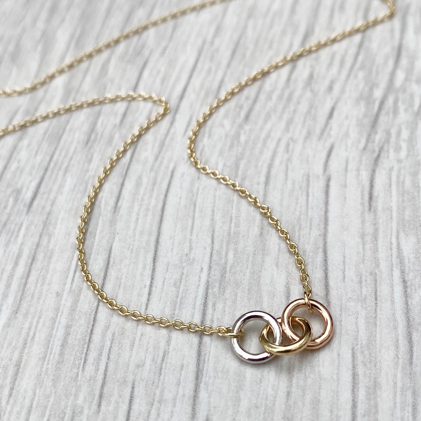 9ct solid yellow, white and rose gold three linked rings necklace with a 9ct yellow gold trace chain
