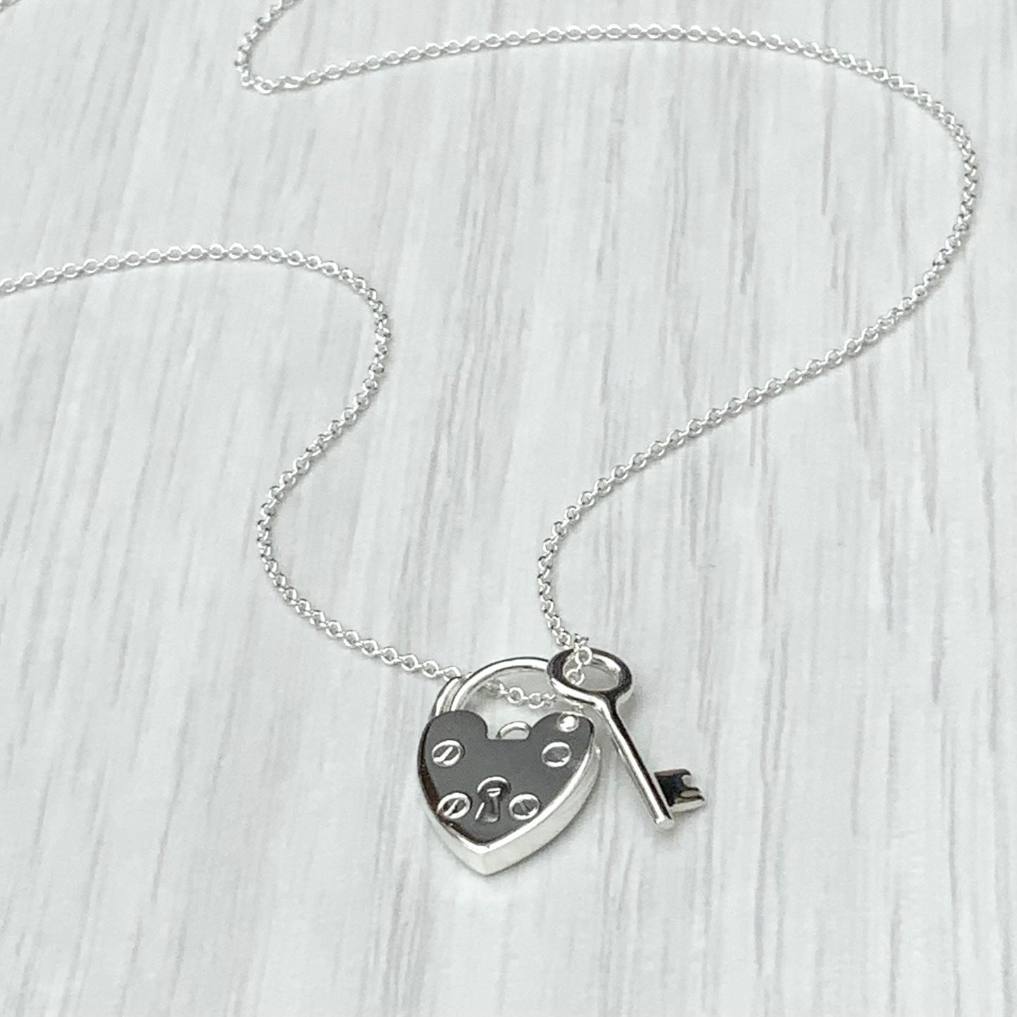 Solid silver heart padlock and dainty key charm pendant on a trace chain
