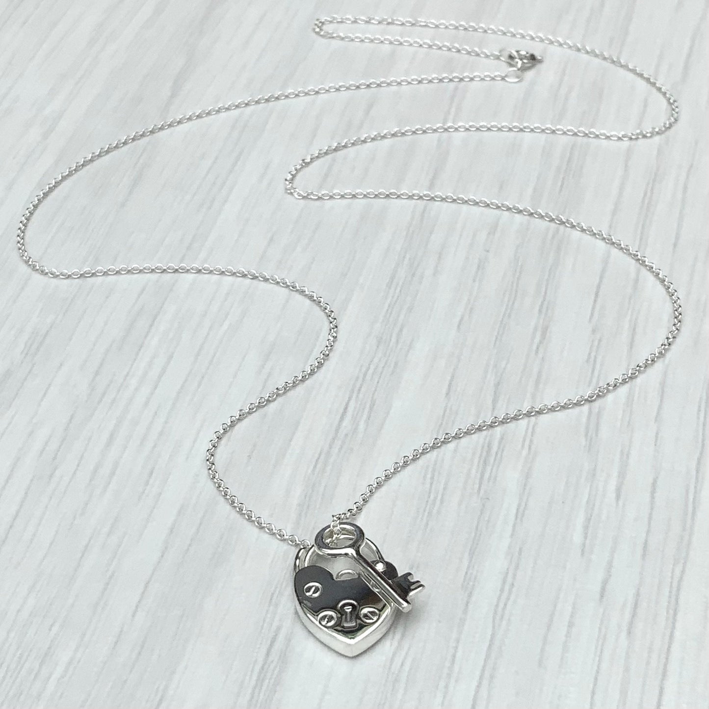 Solid silver heart padlock and dainty key charm pendant on a trace chain